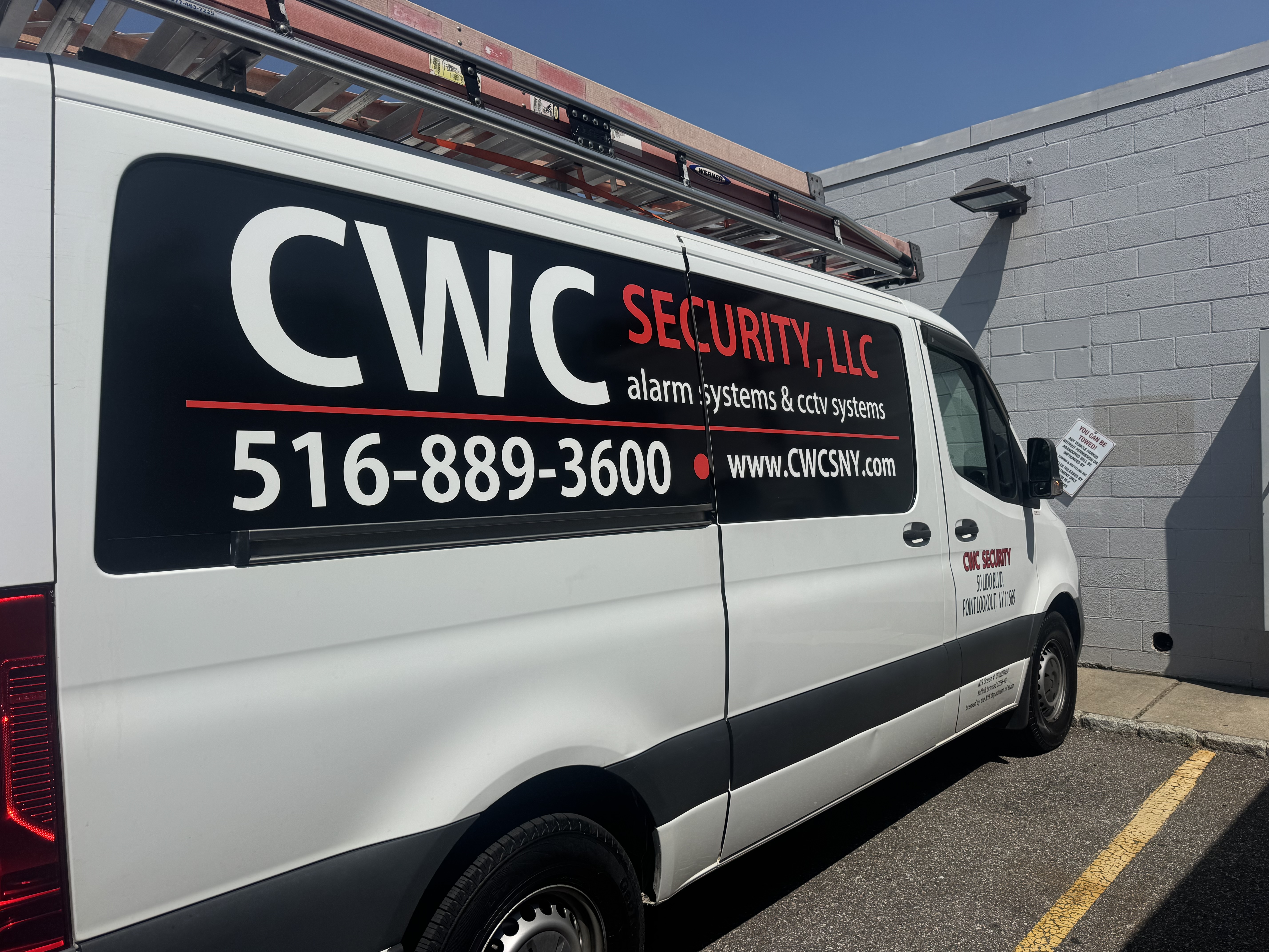 Close-up of CWC Security van signage showing alarm systems, CCTV systems, and phone number